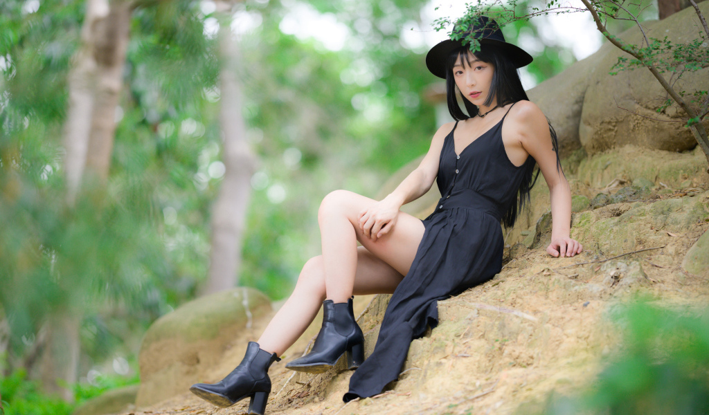 Красивая девушка в черном платье и шляпе