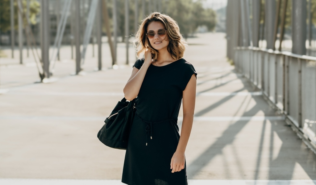 Красивая девушка в черном платье в очках