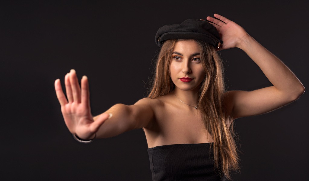 Красивая девушка в кепке на черном фоне