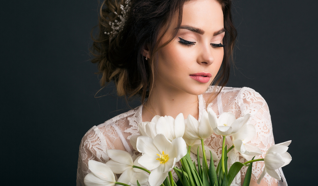 Красивая девушка с букетом белых тюльпанов на сером фоне