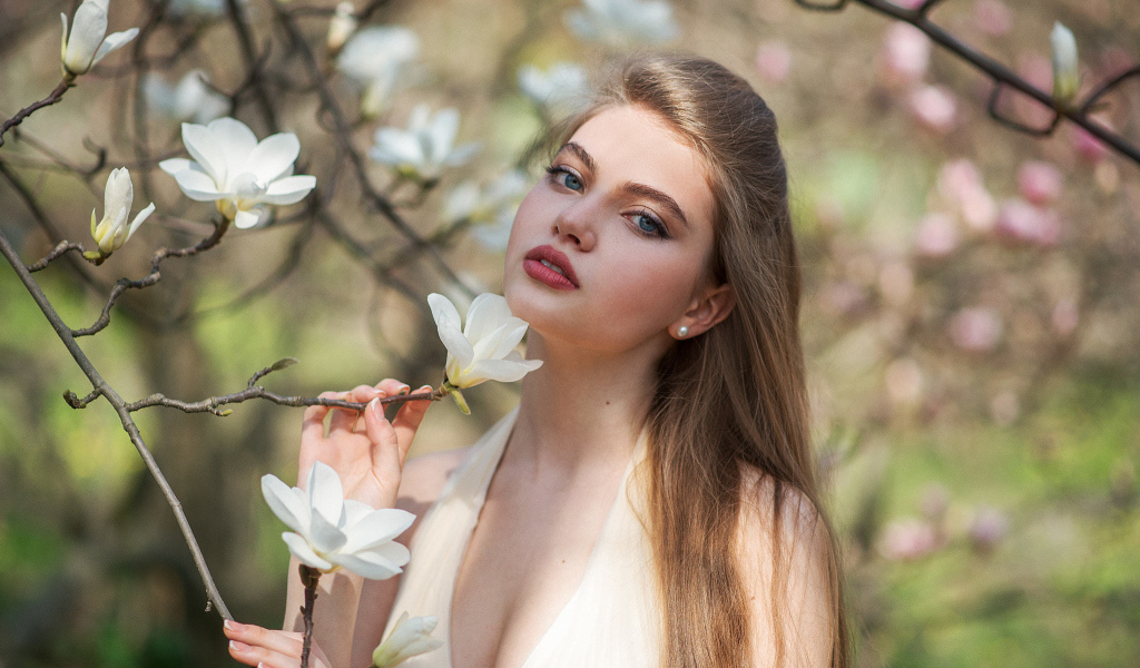Красивая девушка с белыми цветами магнолии