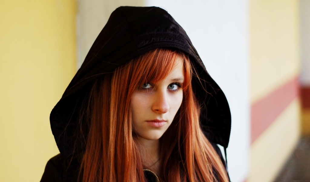 Красивая рыжеволосая девушка в черном балахоне