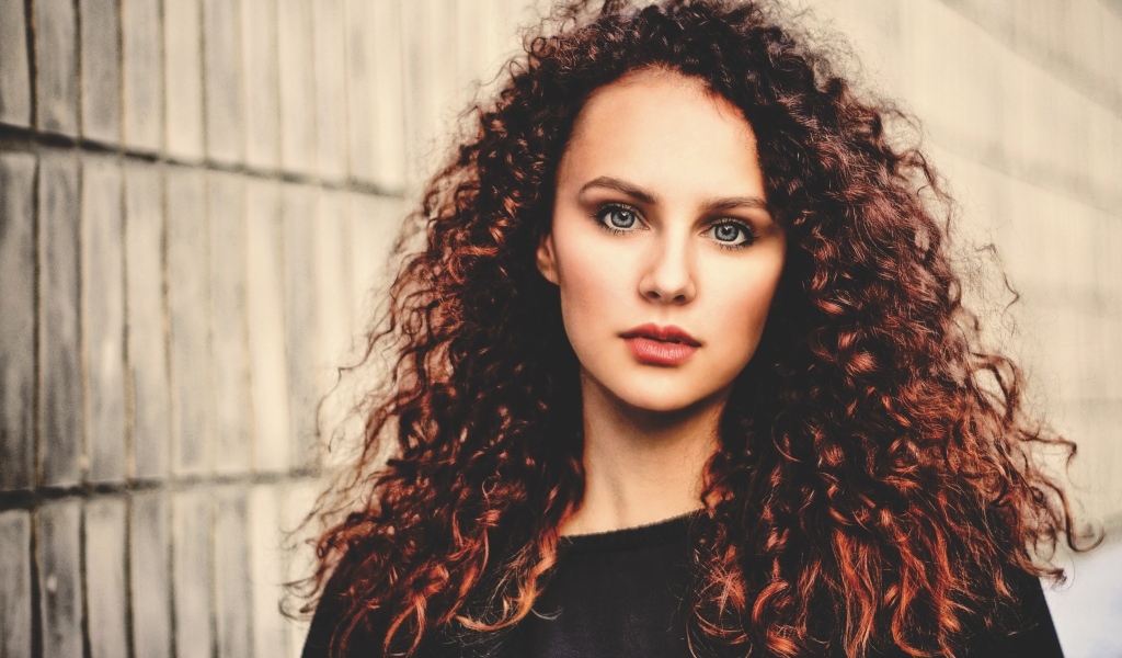 Кудрявые красивые волосы у девушки с серыми глазами