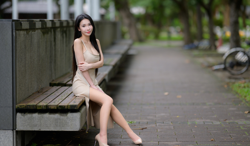 Милая девушка азиатка сидит на лавке