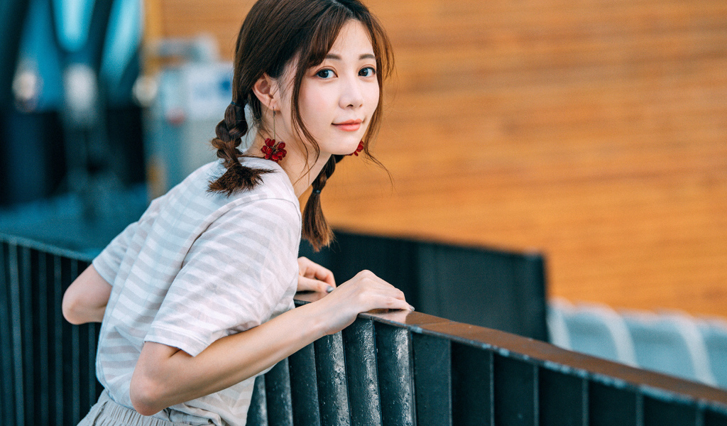 Милая девушка азиатка с косичками на голове 