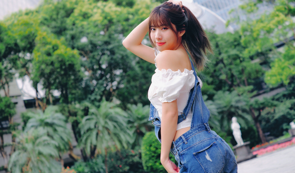 Милая девушка азиатка в джинсовом комбинезоне