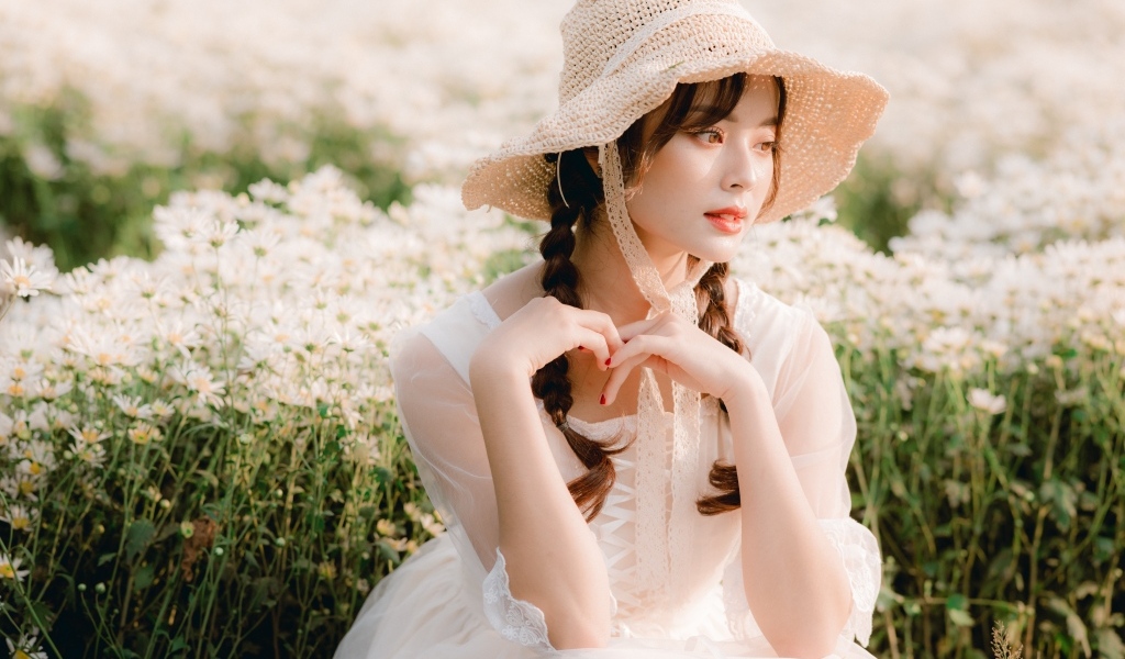 Милая азиатка в шляпе и белом платье 
