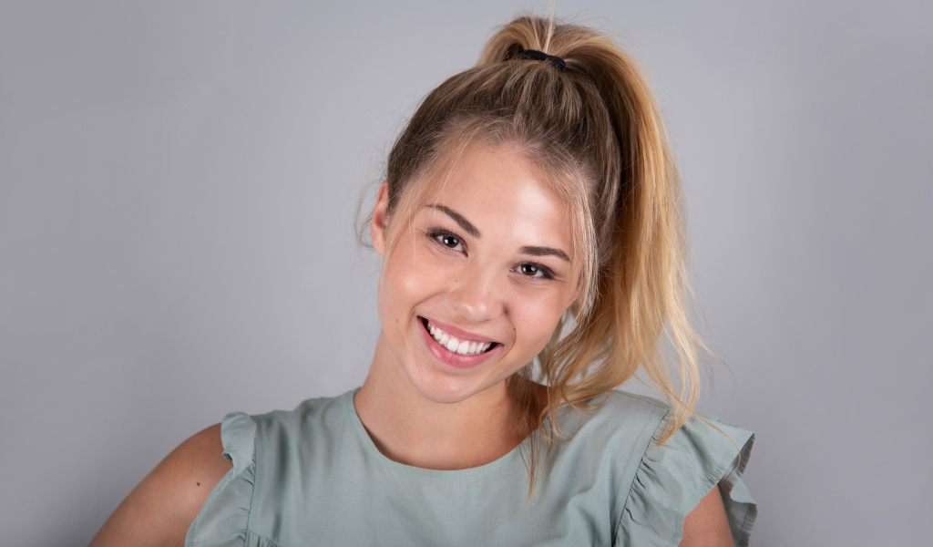 Милая блондинка на сером фоне