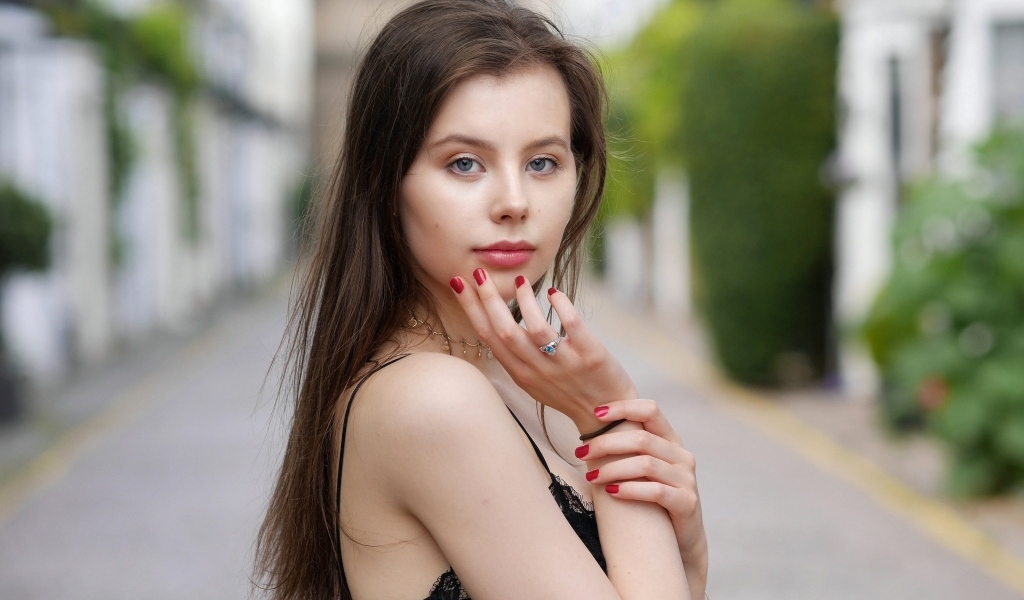 Милая голубоглазая девушка с красным маникюром