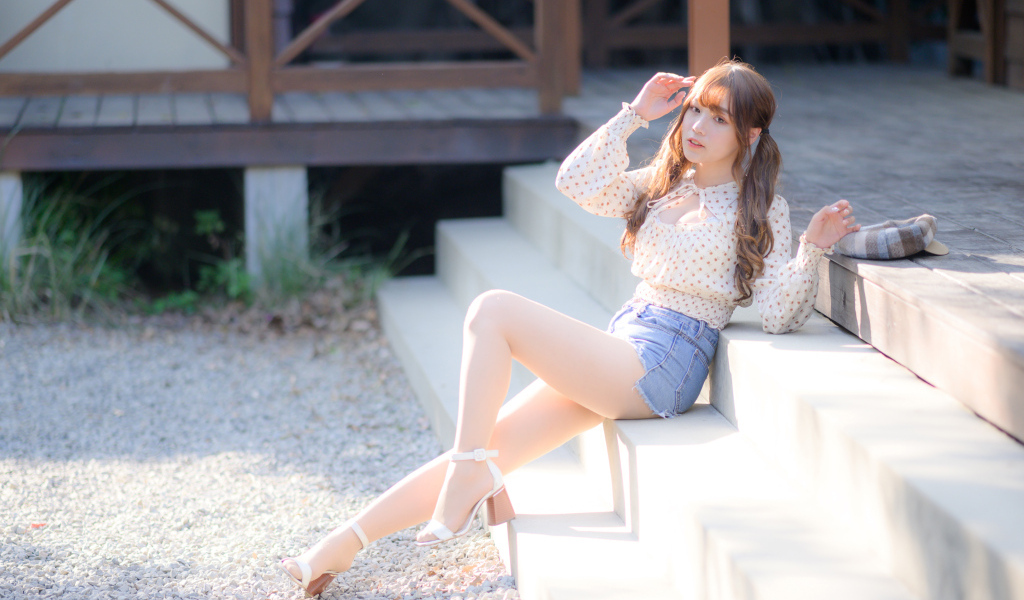 Милая настоящая азиатка сидит на ступеньках