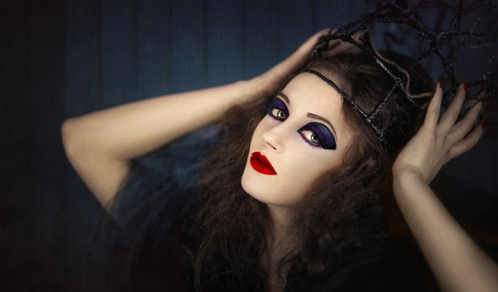 Девушка в черном наряде с ярким макияжем