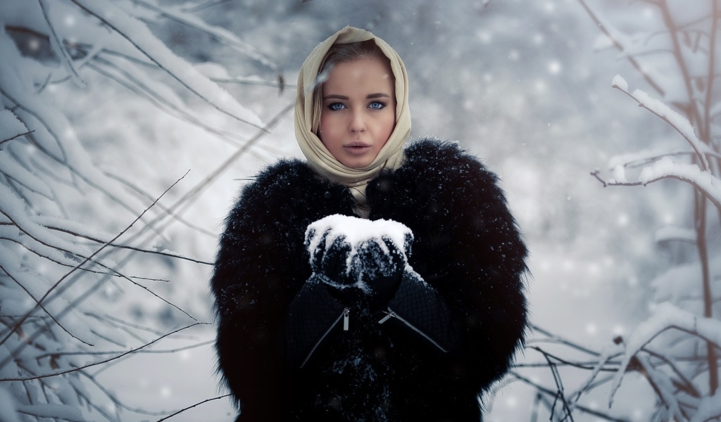 Девушка в черной шубе в заснеженном лесу