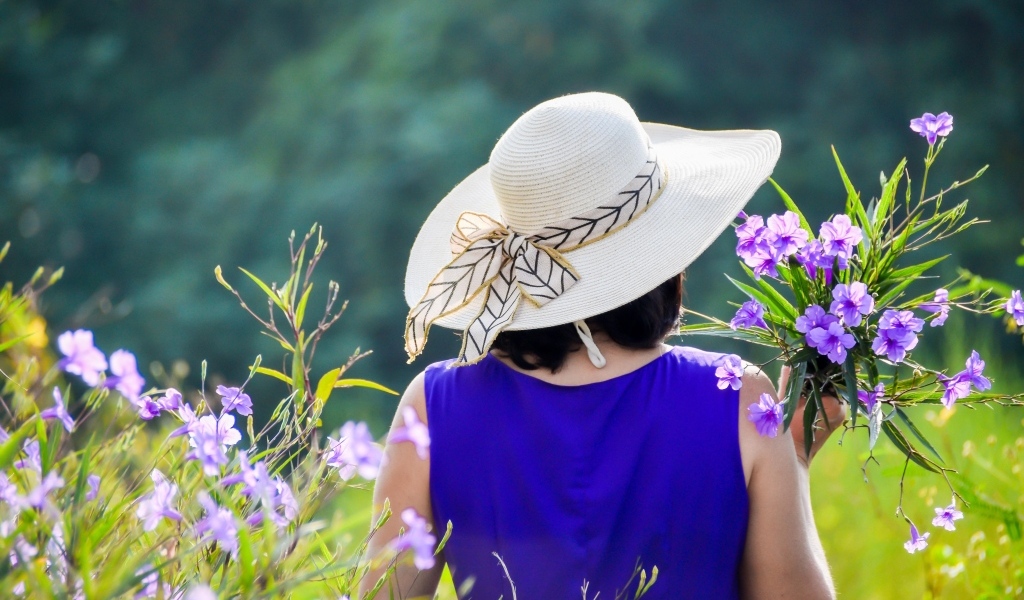 Девушка в шляпе с букетом полевых цветов