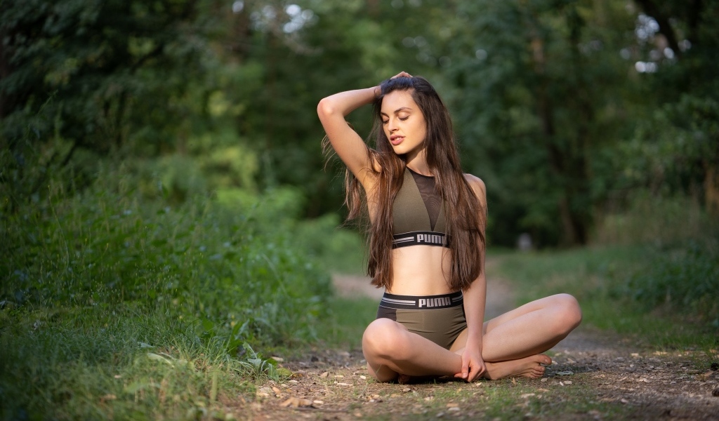 Девушка сидит в позе лотоса в осеннем парке