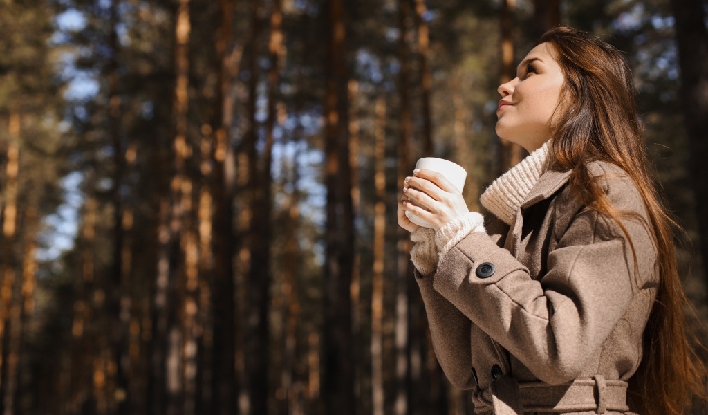 Девушка с чашкой кофе в парке