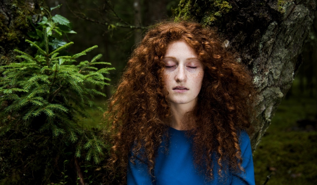 Девушка с кудрявыми волосами в лесу