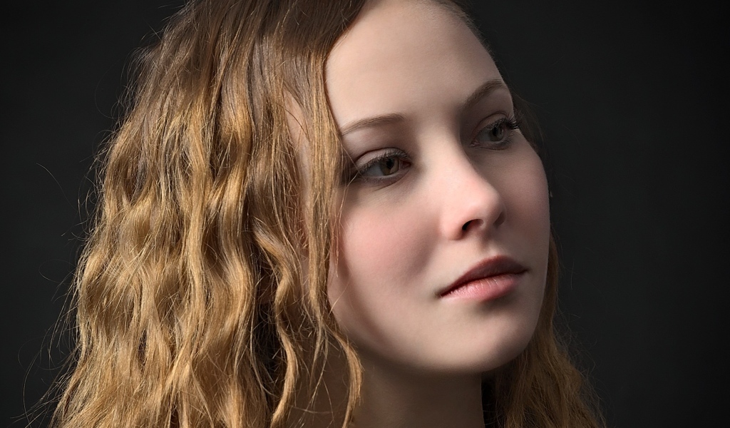 Длинноволосая кареглазая девушка на черном фоне