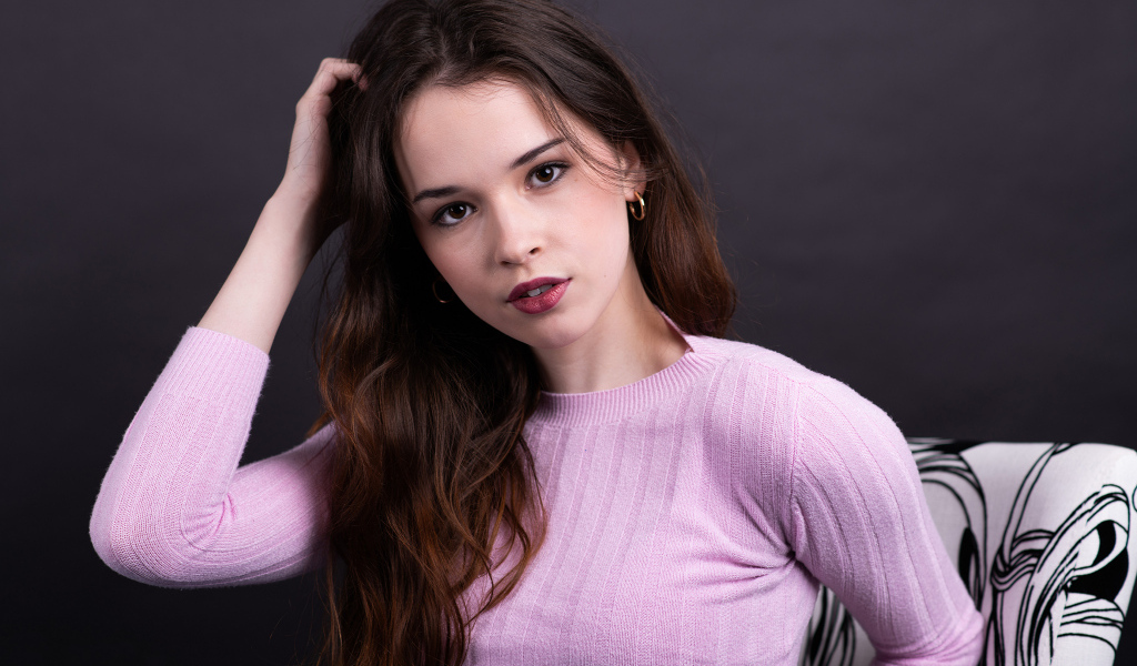 Длинноволосая шатенка в свитере с рукой в волосах