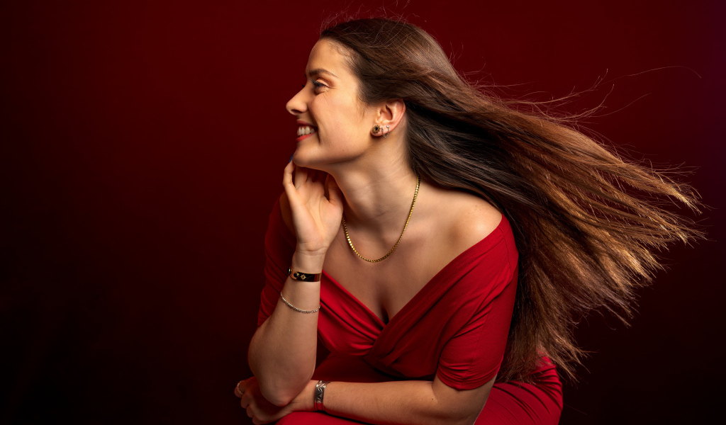 Длинные волосы у красивой девушки в красном платье