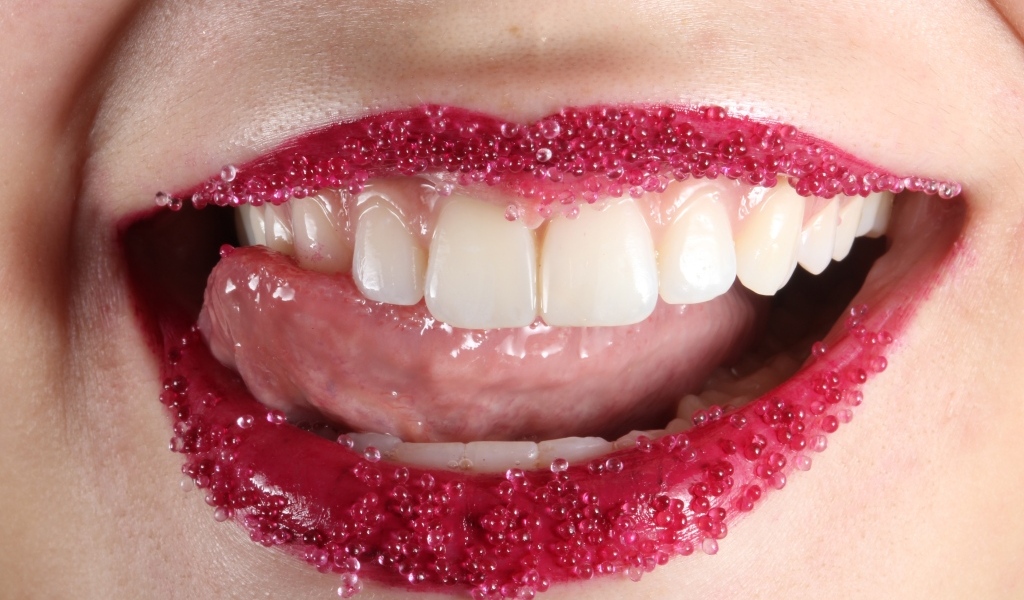 Красные губы девушки с красивыми зубами