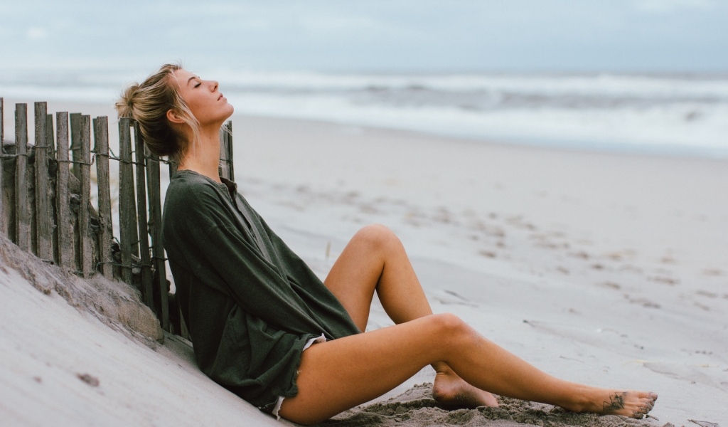 Романтическая девушка лежит на песке у моря