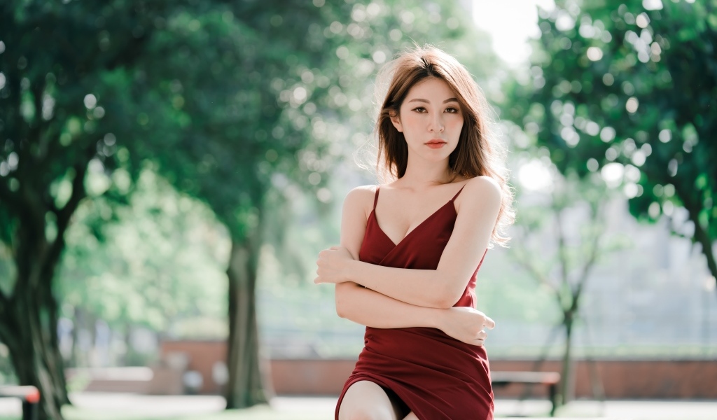 Серьезная девушка азиатка в красном платье