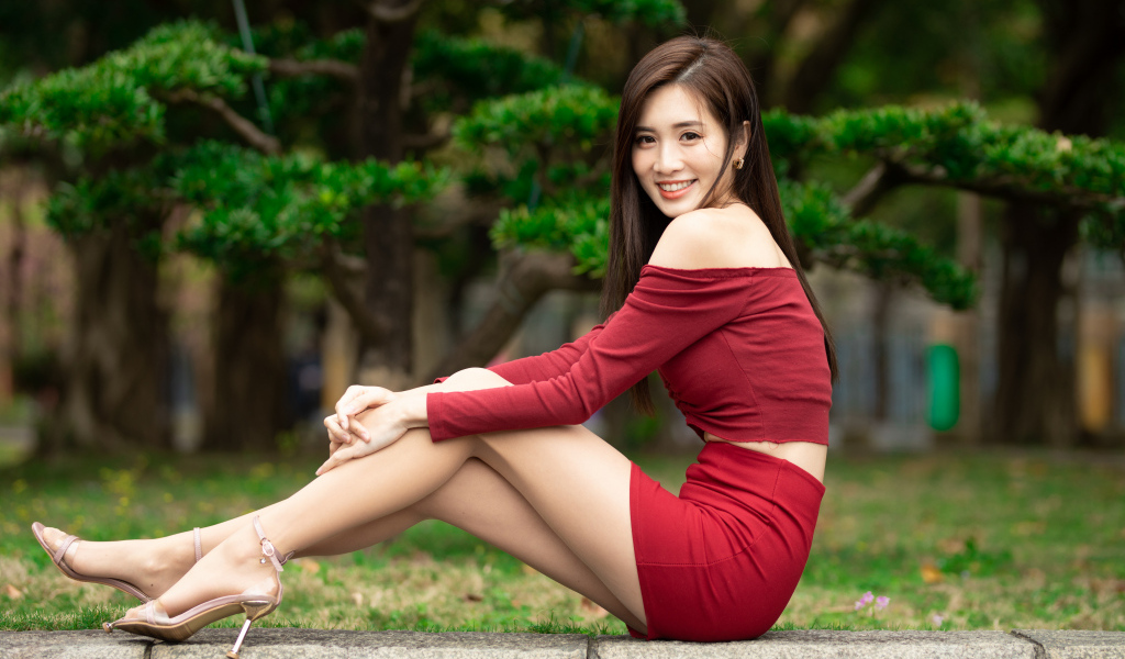 Улыбающаяся азиатка в красном костюме