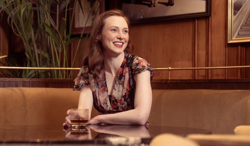 Улыбающаяся девушка за столиком в кафе