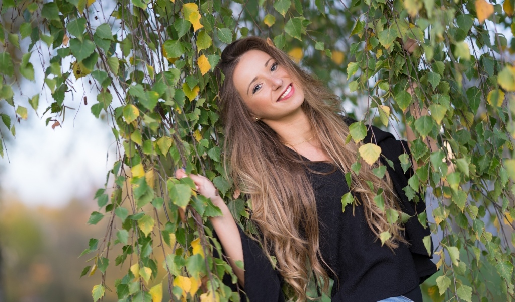 Улыбающаяся девушка в ветках березы