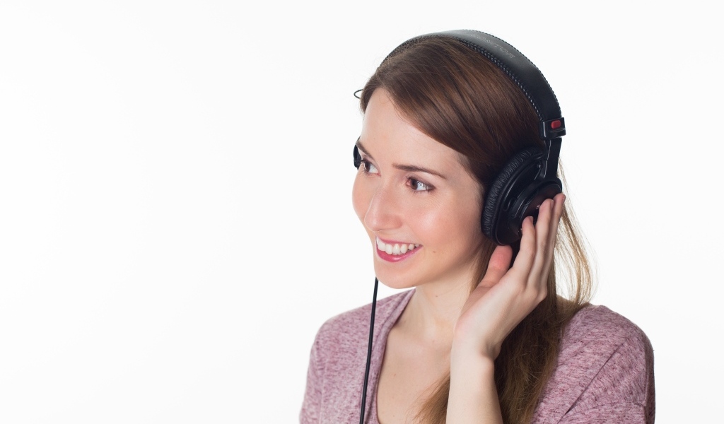 Улыбающаяся девушка в черных наушниках