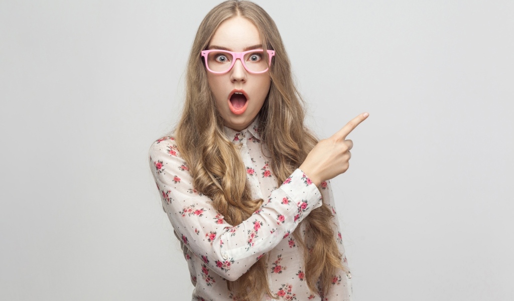 Удивленная девушка на сером фоне