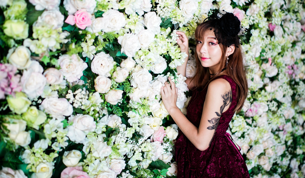 Молодая азиатка на фоне стены с розами