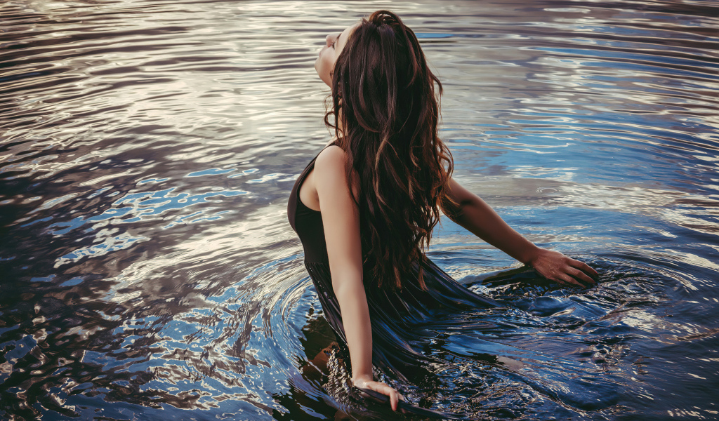 Молодая девушка купается в воде