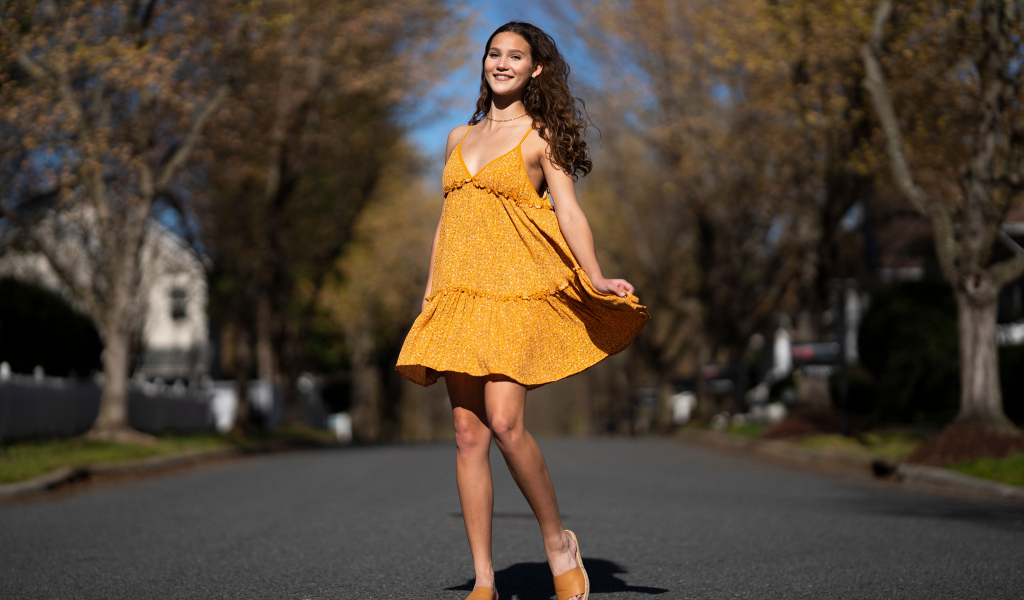 Молодая девушка в коротком платье на дороге  летом