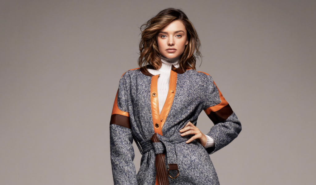 Стильная молодая модель Миранда Керр в пальто на сером фоне