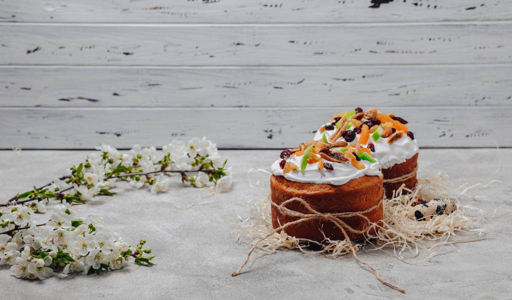 Красивые пасхальные куличи с веткой вишни на сером столе на Пасху