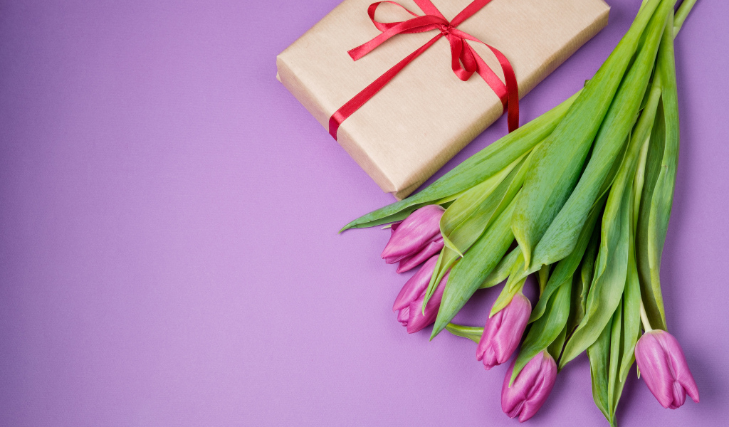 Подарок и букет красивых тюльпанов на сиреневом фоне