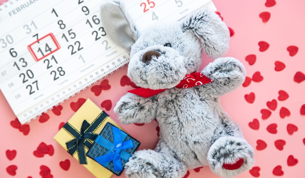 Игрушка и календарь на розовом фоне