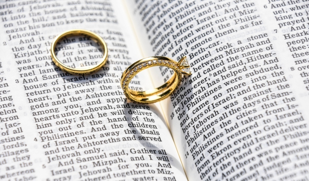 Два золотых обручальных кольца лежат на газете