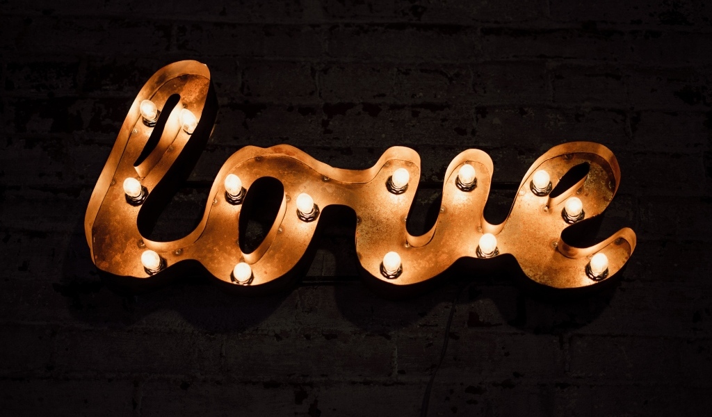 Светящаяся надпись любовь на черной стене