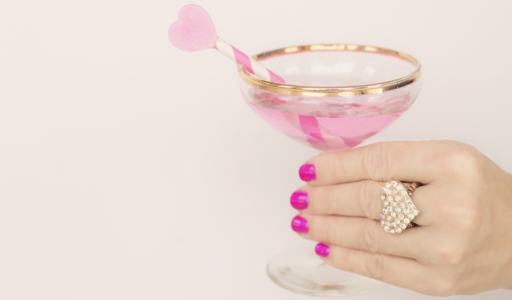 Кольцо в форме сердца на руке девушки с бокалом