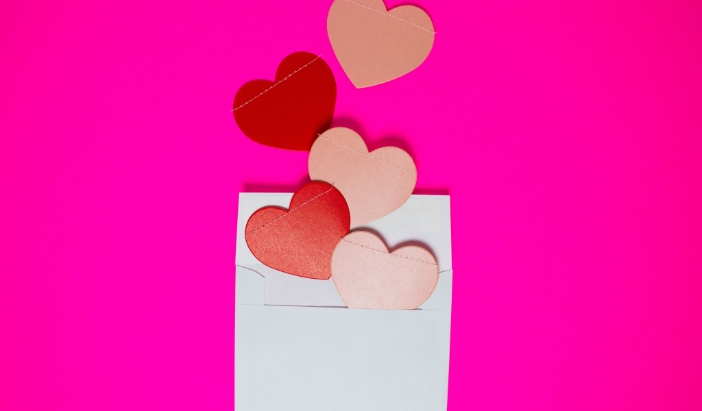 Сердечки с белым конвертом на розовом фоне