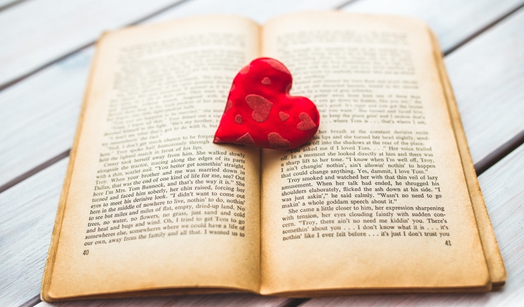 Маленькое красное сердце с книгой на столе