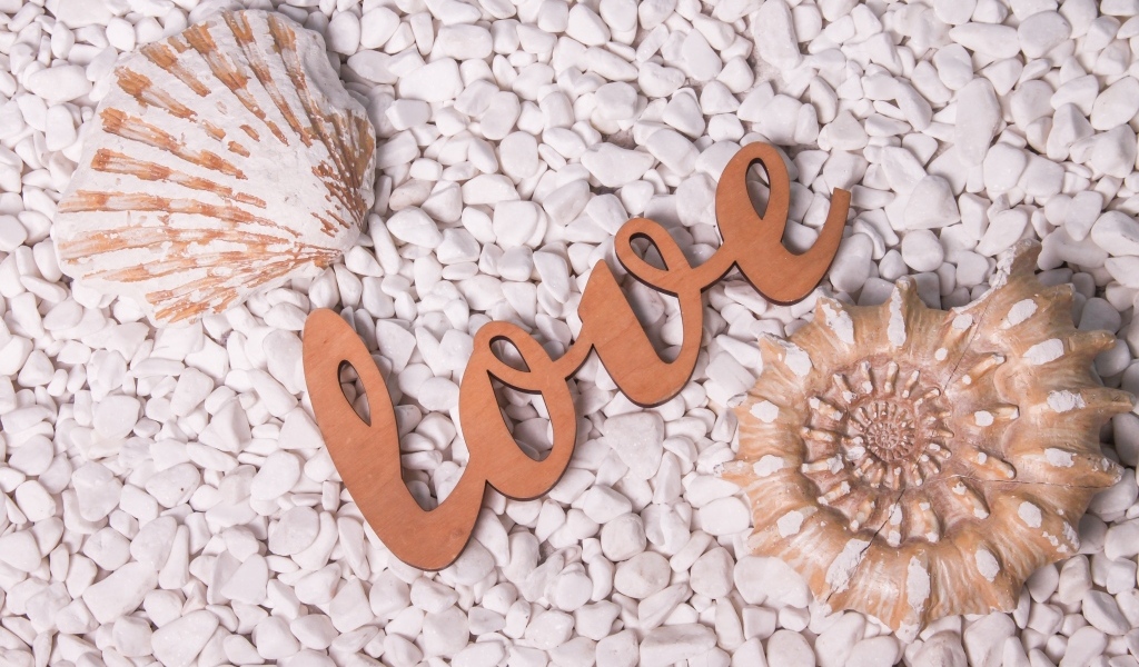 Ракушки и надпись любовь на белых камнях