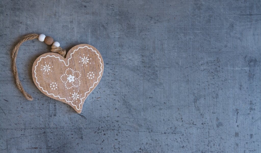 Деревянное сердце на нитке на сером фоне