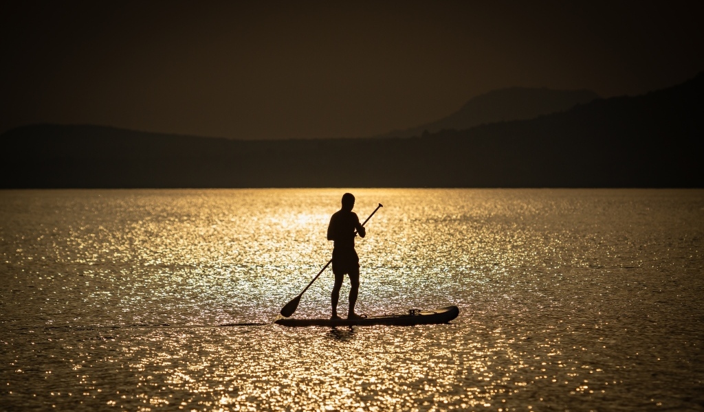 Мужчина серфингист в море на закате