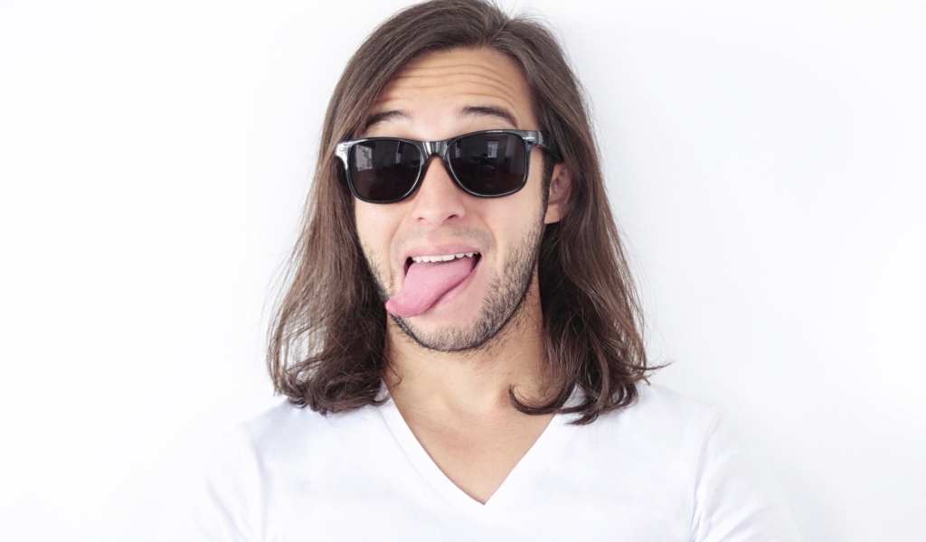 Мужчина в очках с высунутым языком