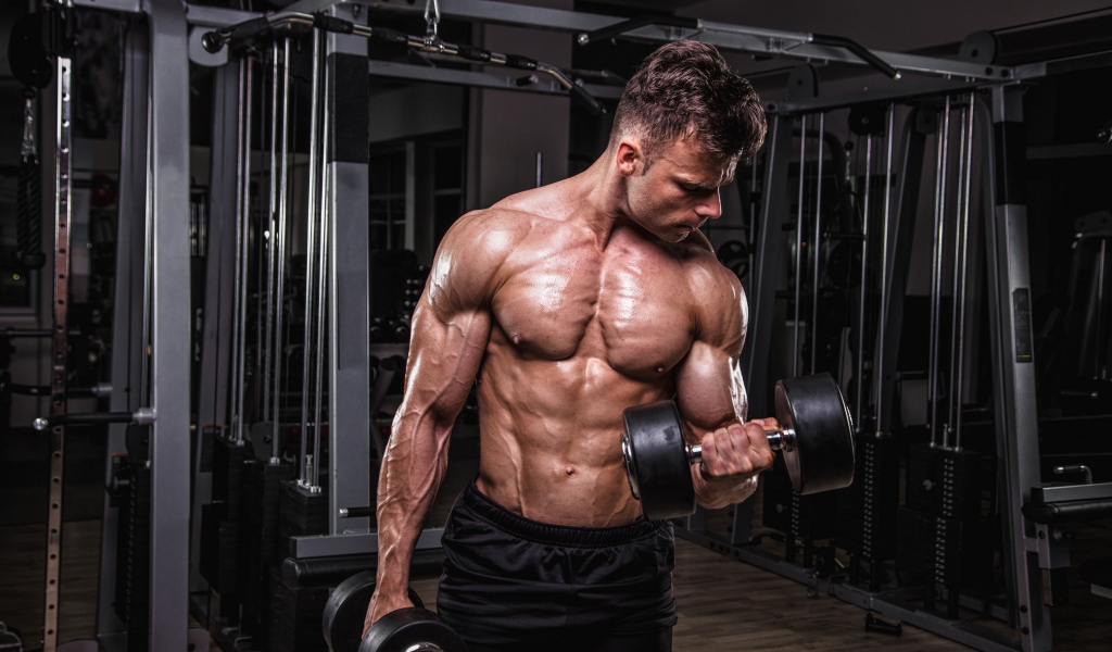 Сильный мужчина качает мускулы 