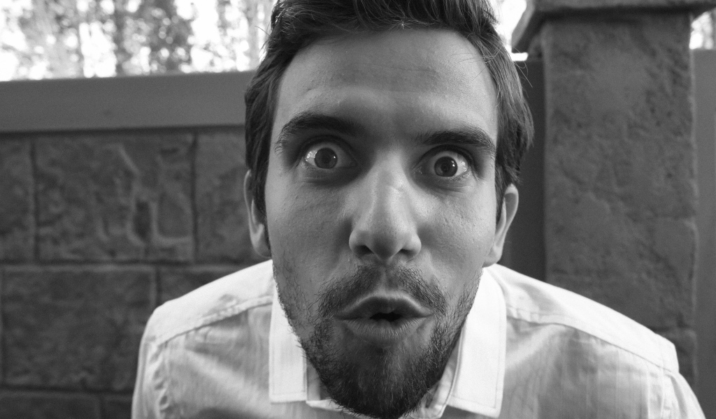 Удивленный взгляд мужчины в белой рубашке