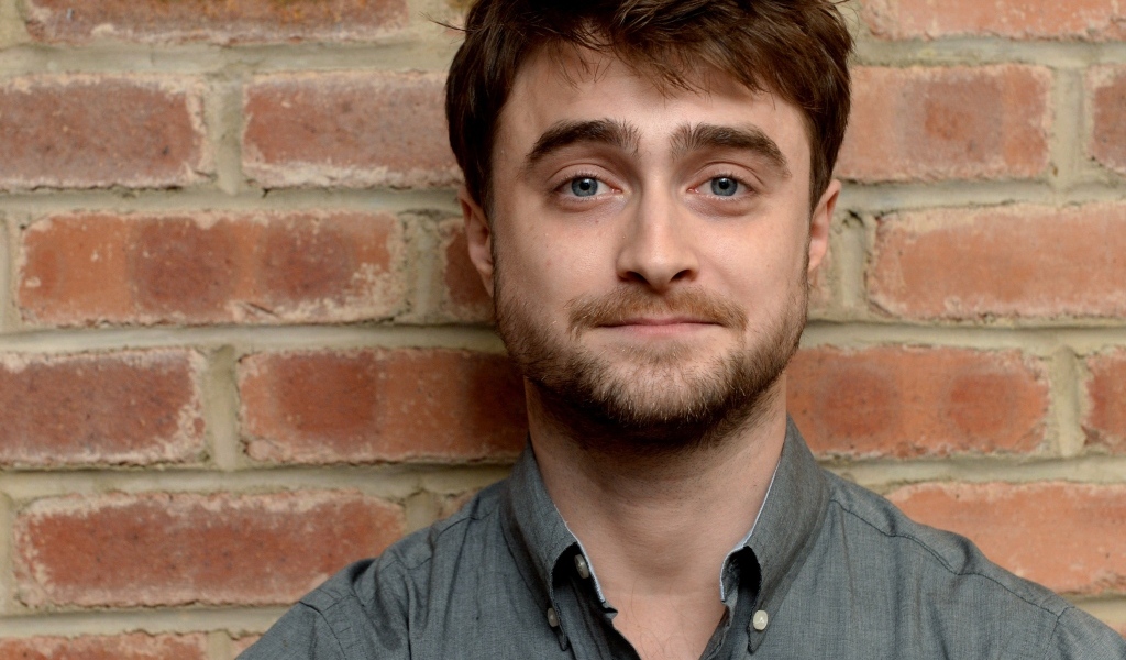 Актер Дэниел Рэдклифф стоит у стены